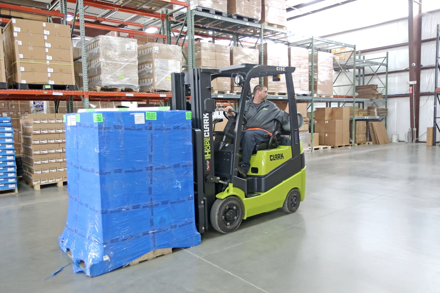 Clark C15C forklift moving a wrapped pallet past pallet racking in a Lehigh Valley warehouse